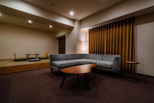 a living room with a couch and a table at Randor Hotel Sapporo Suites in Sapporo
