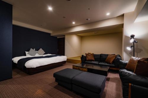 a hotel room with a bed and a couch at Randor Hotel Sapporo Suites in Sapporo
