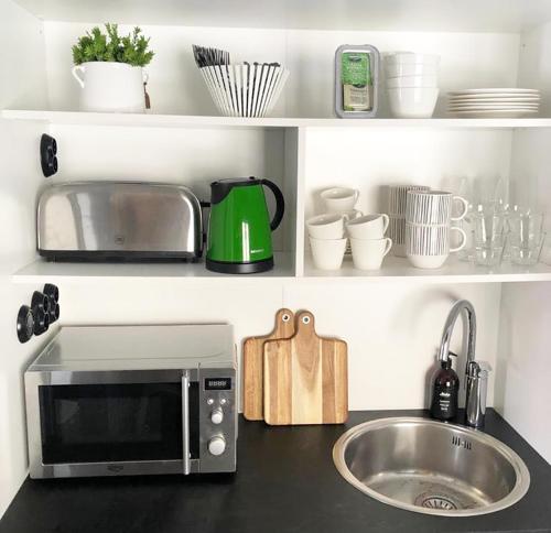 a kitchen counter with a microwave and a sink at Eleonora Bed & Breakfast in Kristiinankaupunki