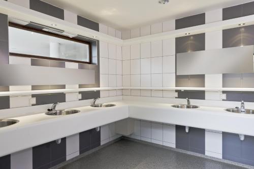 a bathroom with three sinks and a window at Barrels am Clerve in Enscherange