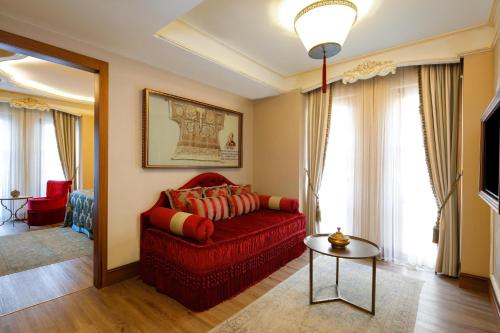 a living room with a red couch and a table at Romance Istanbul Hotel Boutique Class in Istanbul