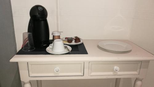 una mesa blanca con una cafetera encima en Hostal La Campana, en Toledo