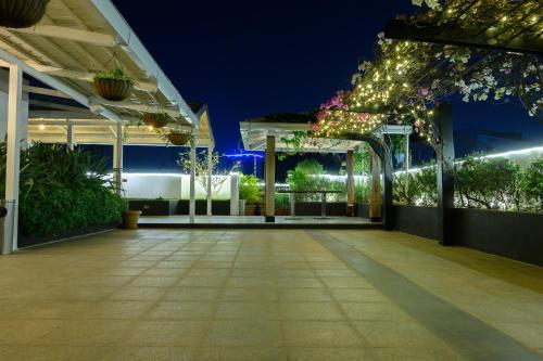 an empty patio at night with lights and plants at Melange Astris in Bengaluru