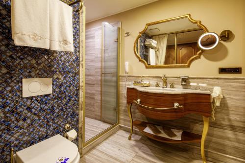 a bathroom with a sink and a mirror and a toilet at Romance Istanbul Hotel Boutique Class in Istanbul