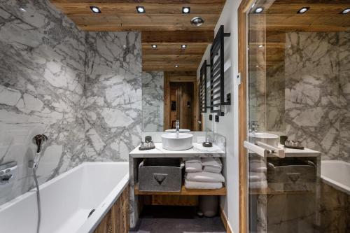 une salle de bain avec une baignoire et un lavabo dans l'établissement Penthouse Best View - Les Chalets COVAREL, à Val dʼIsère