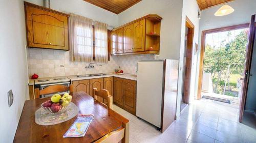 a kitchen with a table with a bowl of fruit on it at Villa Angela, seafront apartments, Almiros beach in Almiros Beach