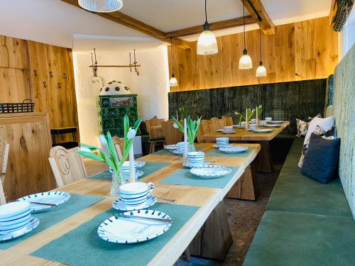 einen langen Holztisch mit blauen und weißen Gerichten darauf in der Unterkunft Wengerbauer in Dorfgastein