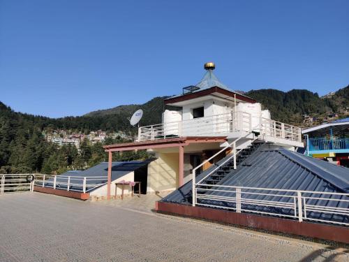 a building with a balcony on top of a roof at Nomadic Inn in Dharamshala
