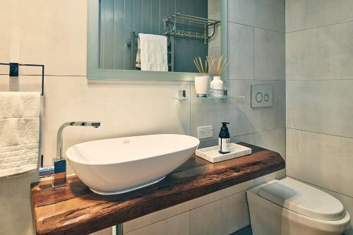 een badkamer met een grote witte wastafel op een houten aanrecht bij Dunstan Times in Clyde