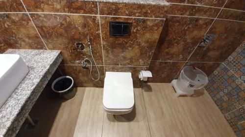 a bathroom with a toilet and a shower at Nomadic Inn in Dharamshala