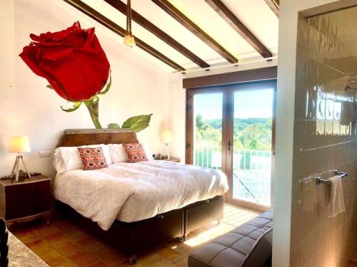 a bedroom with a bed with a red rose on the wall at Secrets Rural House in Jávea