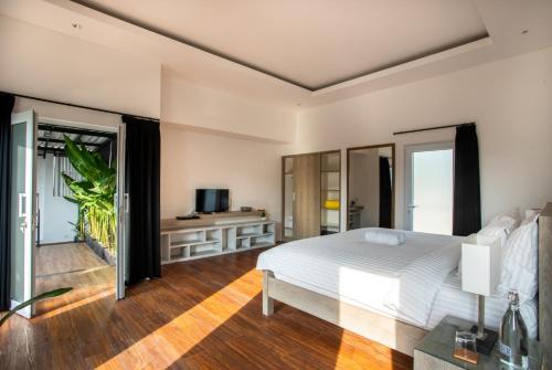 a bedroom with a white bed and a balcony at La Terra Villas Canggu Kuta Bali in Canggu