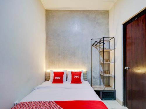 a bedroom with a bed with two red pillows at OYO 90215 Ada Residence in Poponcal 2