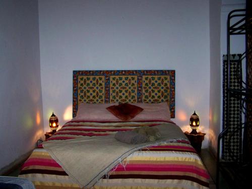 a bedroom with a large bed with two lamps at Dar Rbab in Fès