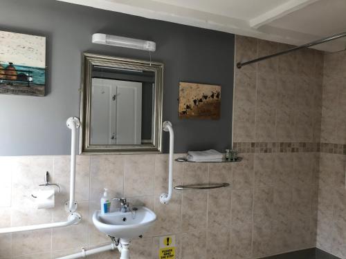 ein Badezimmer mit Waschbecken und Spiegel in der Unterkunft The Cross Guest House in Mablethorpe