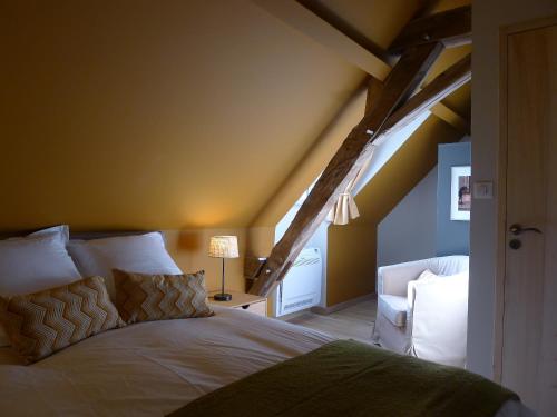 a bedroom with a bed in a room with an attic at Gîte Château de Peyrel in Prigonrieux