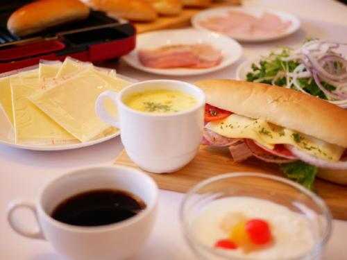 una mesa con un sándwich y dos tazas de café en APA Hotel Utsunomiya-Ekimae, en Utsunomiya