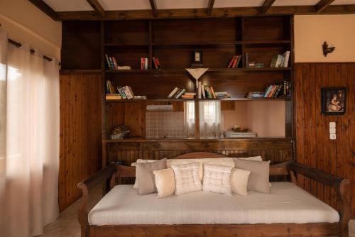 a bed with pillows in a room with wooden walls at Villa Georgia in Kalyves