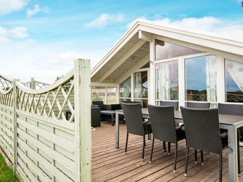 a wooden deck with a table and chairs on it at 6 person holiday home in R m in Bolilmark