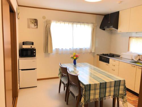 a kitchen with a table with a vase of flowers on it at Izu Shirada Villa 伊豆白田家 in Higashiizu