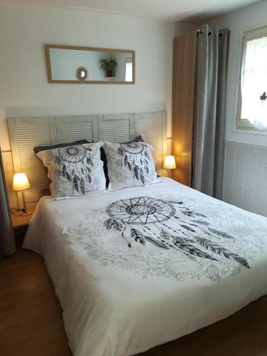 une chambre avec un grand lit blanc avec deux lampes dans l'établissement Gîte Les Hortensias, à Vaas