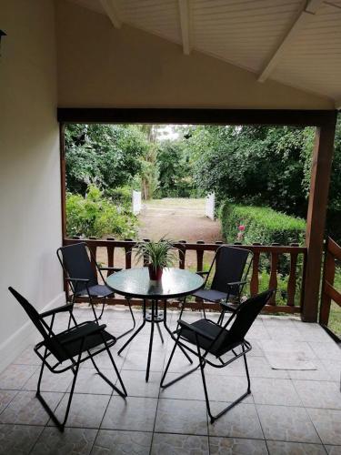 un patio avec une table et des chaises sur un porche dans l'établissement Gîte Les Hortensias, à Vaas