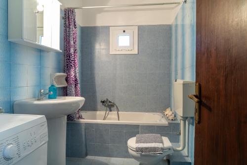 a bathroom with a tub and a sink and a toilet at The View in Makry Gialos