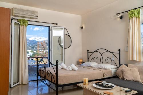 a bedroom with a bed and a couch and a window at The View in Makry Gialos