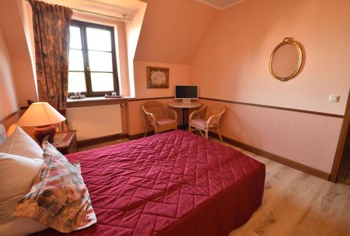 a bedroom with a bed and a table with a mirror at Pension zur Königlichen Ausspanne Dresden in Dresden