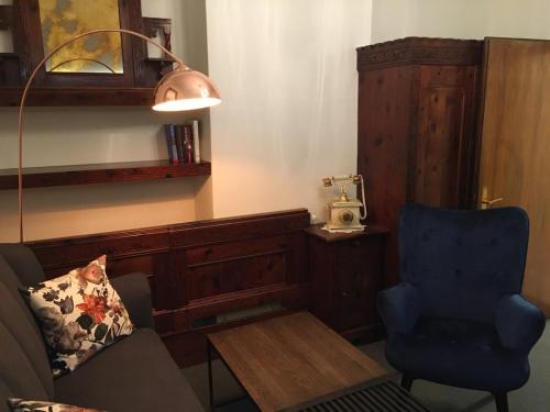 a living room with a couch and a chair and a lamp at Cityhotel Ratheiser in Klagenfurt