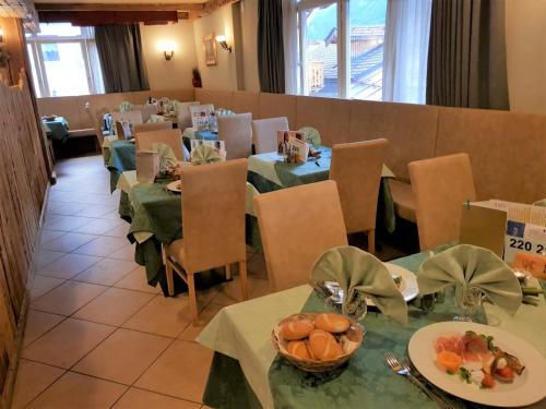 a dining room with tables and chairs with fruit on them at Hotel Bellevue in Canazei