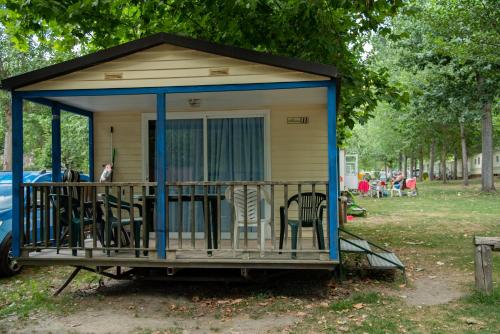 a tiny house with chairs and a porch at Camping Noguera Pallaresa in Sort