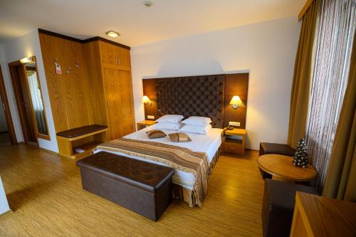 a hotel room with a large bed and a table at Boutique Hotel L do Rado in Sofia