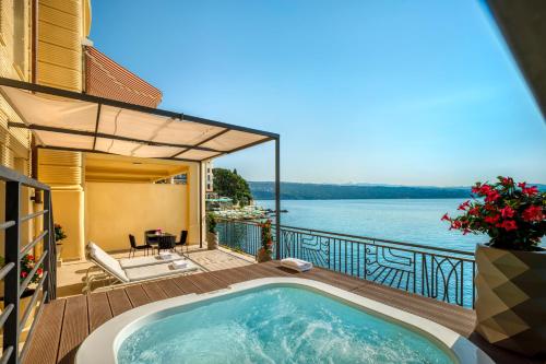 a hot tub on a deck with a view of the water at Hotel Ambasador - Liburnia in Opatija
