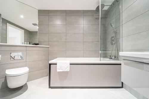 a bathroom with a tub and a toilet and a sink at Seven Living Residences Solihull - Close to NEC & BHX - Free Parking in Solihull