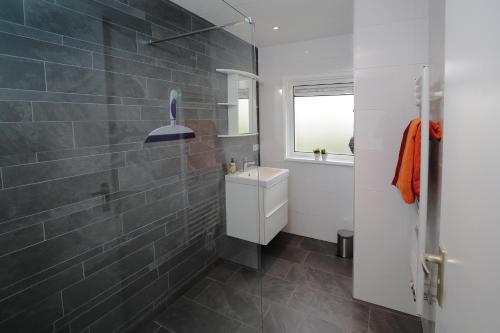 a bathroom with a toilet and a sink and a mirror at Bungalow Sunny, lekker uitwaaien op het strand! in Callantsoog