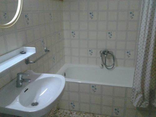 La salle de bains est pourvue d'une baignoire blanche et d'un lavabo. dans l'établissement Apartment Torres Mari, à Cala Llonga