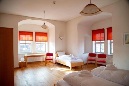 a bedroom with two beds and a table and chairs at Pension Schloss Heringen in Heringen