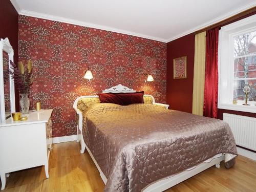 a bedroom with a bed with red wall paper at Condis Lägenheten in Järvsö