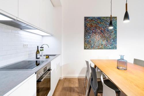 a kitchen with a wooden table and a painting on the wall at BENSIMON apartments Mitte/Wedding in Berlin