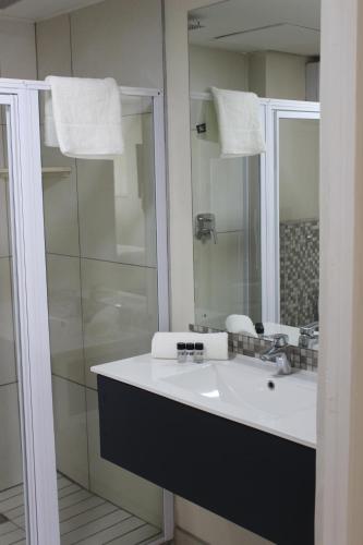 a bathroom with a white sink and a shower at Luxe-Molen Boutique Hotel in Queenstown