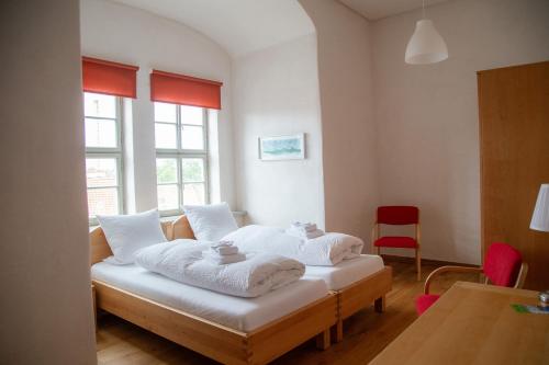 a bedroom with a bed with towels on it at Pension Schloss Heringen in Heringen