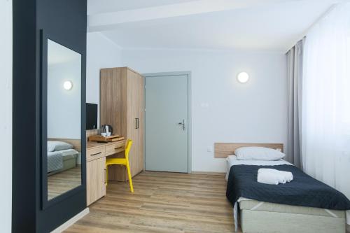 a bedroom with a bed and a desk and a mirror at Centrum Sportu i Rekreacji in Sępólno Krajeńskie