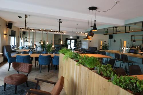 a restaurant with tables and chairs and a bar at Chalet Mariënberg in Mariënberg