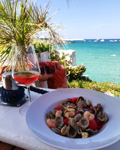 a plate of food on a table with a glass of wine at I Sottani in Monopoli