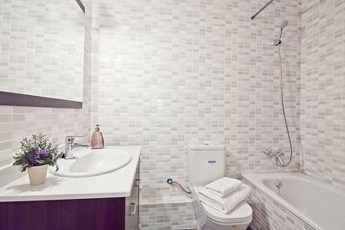 a bathroom with a toilet and a sink and a tub at Lavander in Sitges