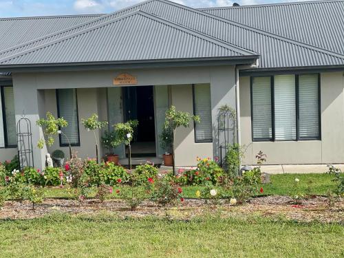 a house with a garden of flowers in front of it at Gibbagunyah Manor Coal & rail workers etc Only in Muswellbrook