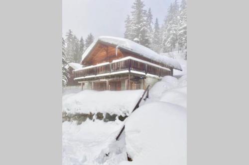 a snow covered cabin with a pile of snow at Magic Ski-In-And-Out Chalet above Verbier in Bagnes