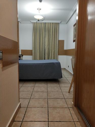a room with a bed and a tile floor at Hostal Maria Ronda in Madrid