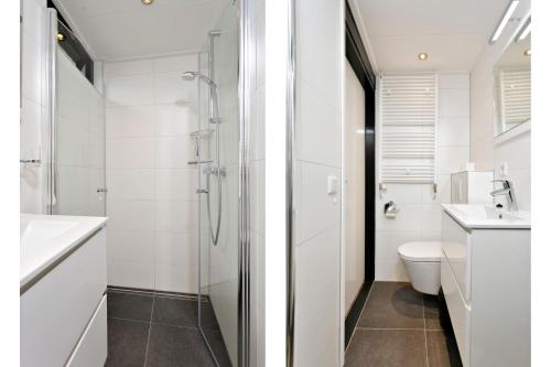 a white bathroom with a toilet and a shower at Horrelshoogte 15, cozy house with private garden near the beach - not for companies in Ouddorp